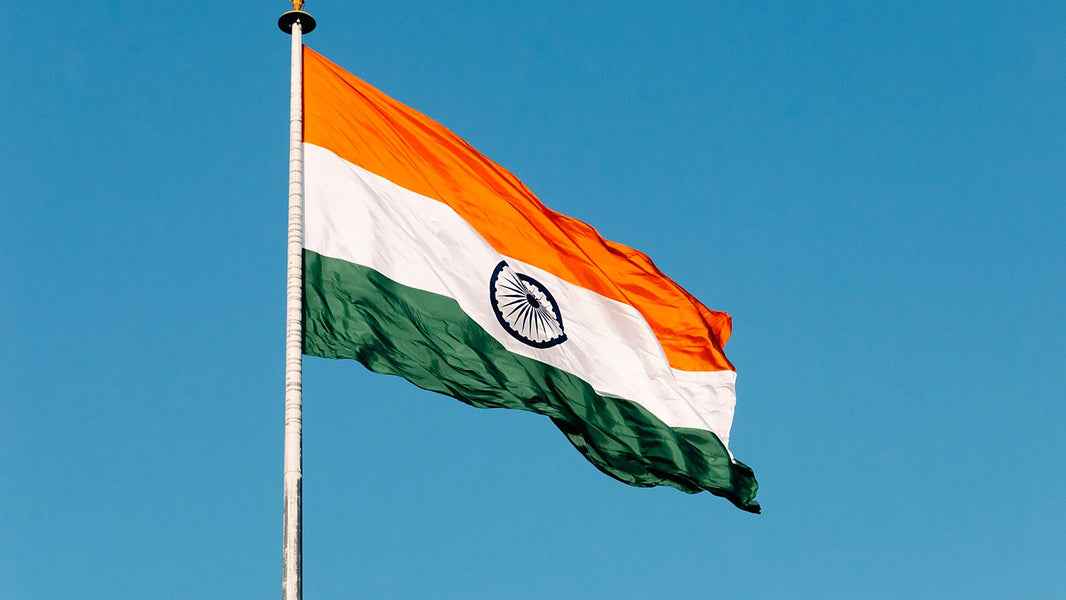 The Indian national flag flying against a clear blue sky